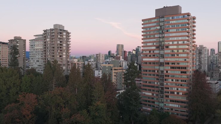 Plano aéreo baixo do Stanley Park durante o nascer da lua em Vancouver, Colúmbia Britânica, Canadá. Vídeos em 4K