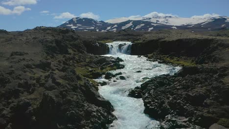 Eine-Drohne-Mit-Reinem-Und-Frischem-Wasser-Flussaufwärts-Zu-Einem-Wasserfall-Im-Hochland-Von-Island-Fliegen
