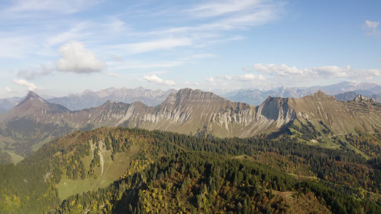 High and slow drone orbit with mountainous landscape in the background, autumn colors Le Folly, the Alps - Switzerland