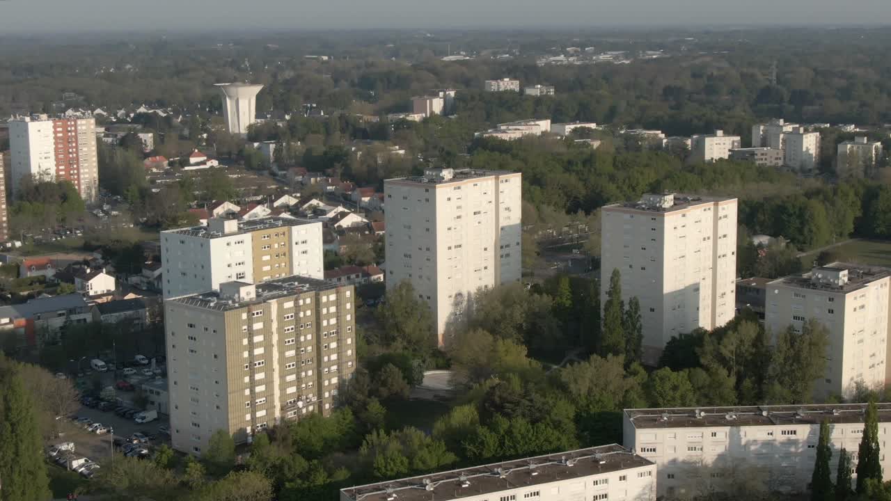Drone footage showcases modern residential apartment buildings in an urban neighborhood of Nantes. Establishing shot for city life, housing concepts. France
