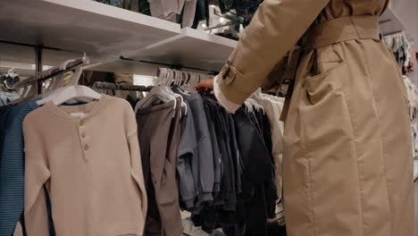 mother shopping for baby clothes for her son at a retail store