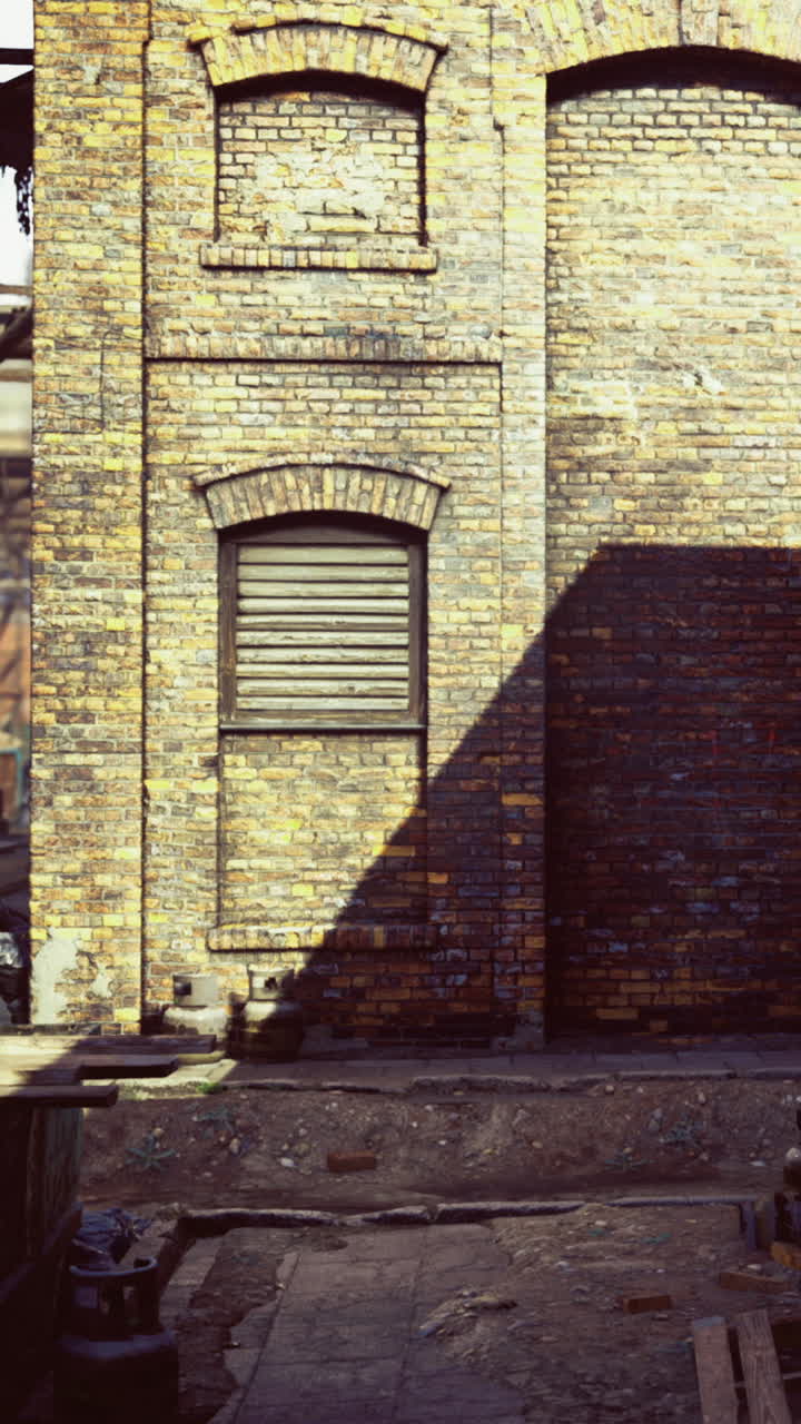 Sombras proyectadas en una vieja pared de ladrillo en una zona industrial desierta.