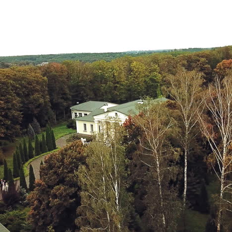 Aerial view of a beautiful architectural building with green roof in the park. Nice building on the natural autumn landscape outdoors.
