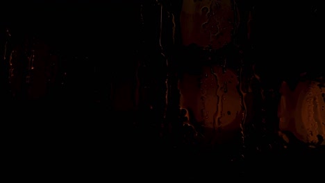 gotas de lluvia en la ventana con la noche o la noche pacífica de la ciudad de fondo detrás. concepto. gotas de agua en el vidrio húmedo con luces bokeh durante la lluvia