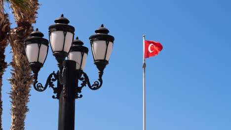 View-Of-Lamppost-With-Flag-of-Northern-Cyprus-Waving-In-Background-Against-Blue-Sky