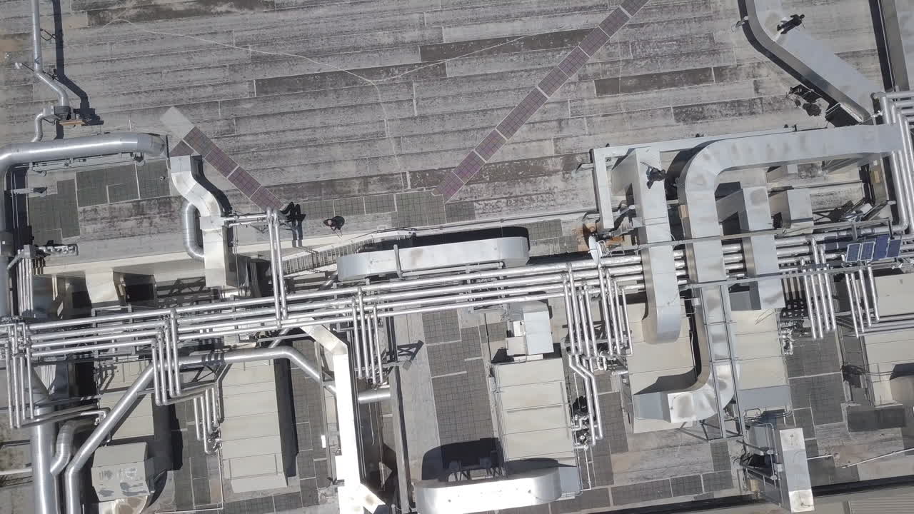 Inquadratura drone in tilt up di agenti armati che hanno messo in sicurezza oggetti vitali del sito tecnologico.