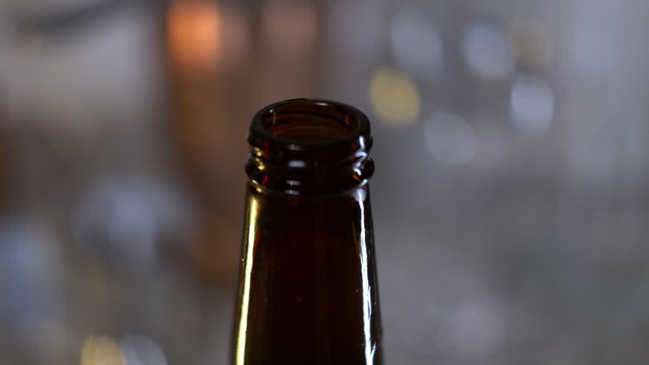 la mano gira la tapa de la botella de cerveza y sale la escarcha