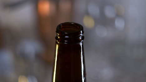 la mano gira la tapa de la botella de cerveza y sale la escarcha