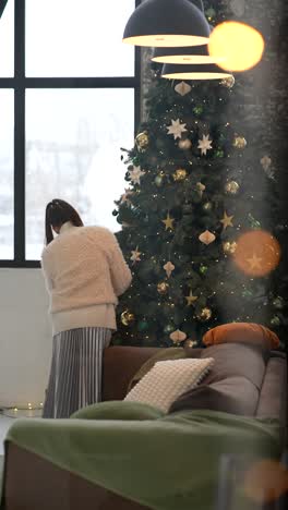 mujer decorando el árbol de navidad en una acogedora sala de estar