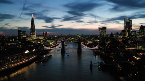 Static-Aerial-View-of-London-over-the-River-Thames-including-Tower-Bridge,-Shard-and-the-Tower-of-London-at-twilight