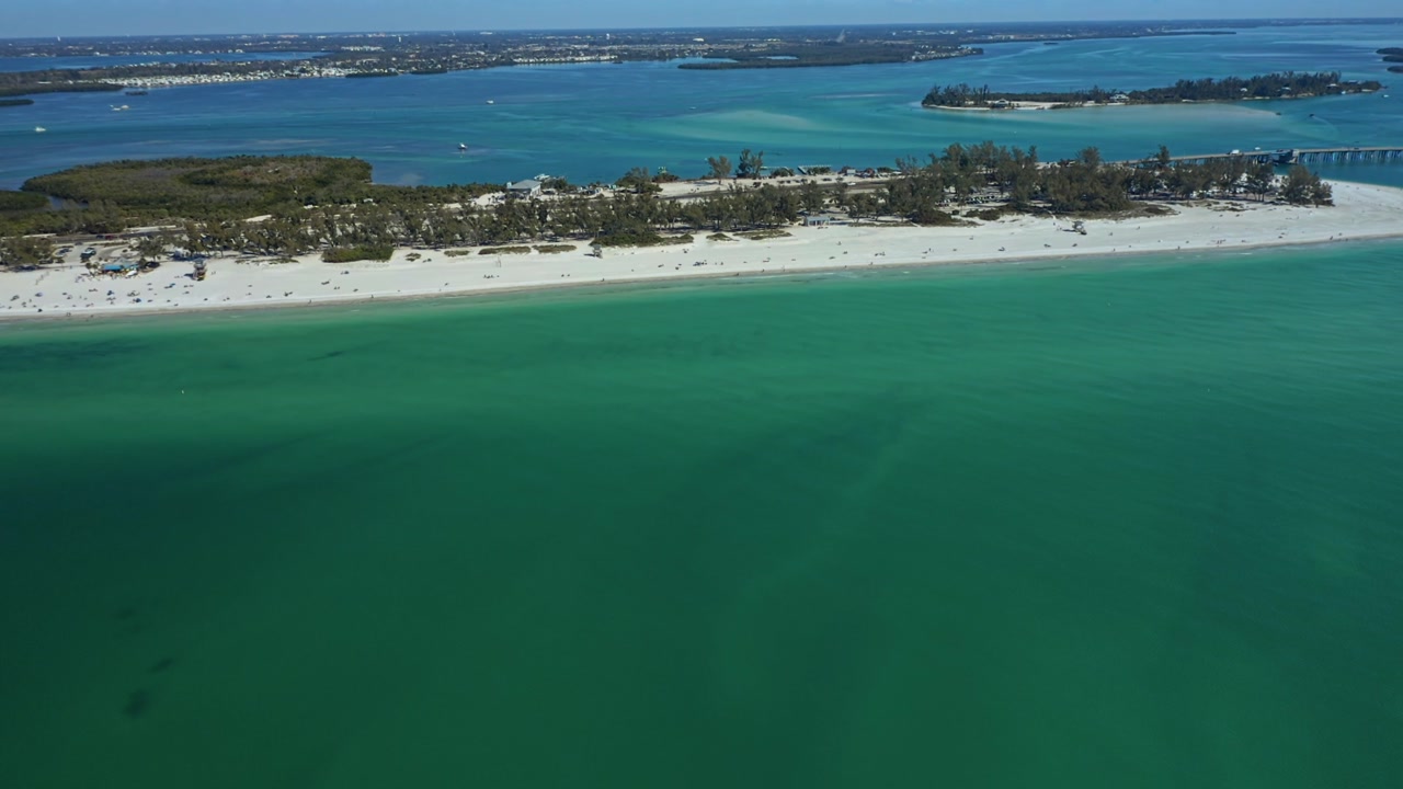 A serene view of Bradenton Beach's expansive shoreline and tranquil emerald waters.