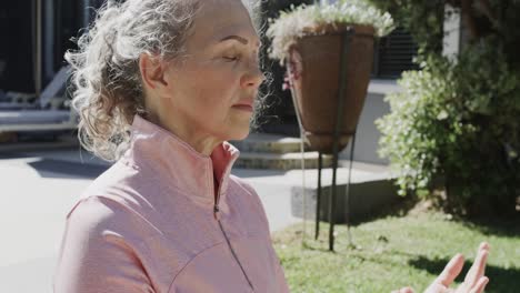 Glückliche-ältere-Kaukasische-Frau,-Die-Yoga-Macht,-Im-Garten-Meditiert,-Zeitlupe