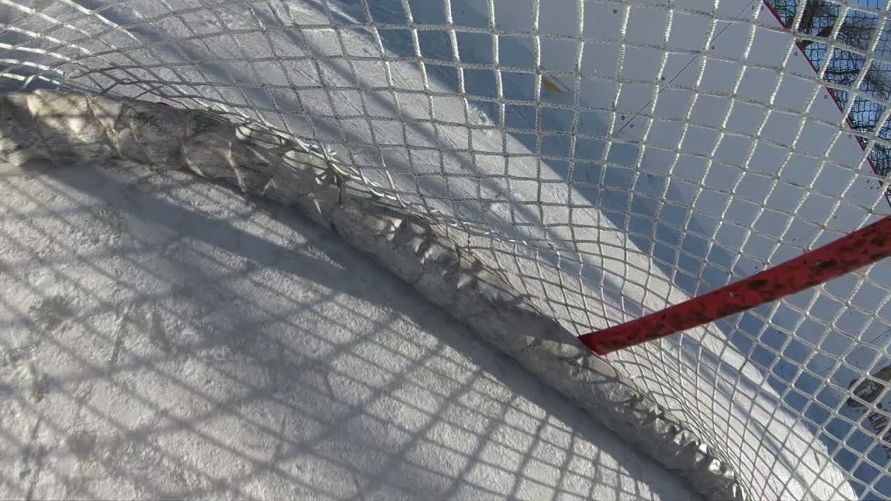 Hockey puck POV scoring goal on empty net