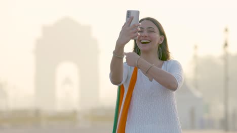 indian girl video calling her friends and family at india gate