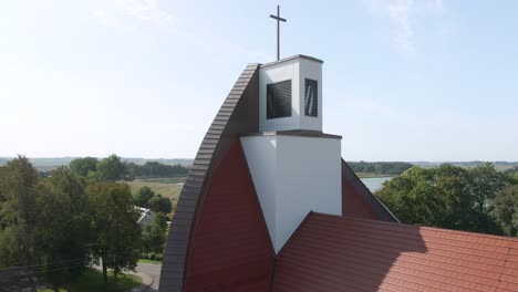 drone ascending view from beautiful red roofed church and revealing bright blue sky of lithuania, aerial drone shot