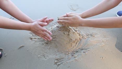 hands shaping and playing with sand