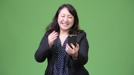 성숙하고 아름다운 아시아 사업가 여성이 드폰을 사용하고 나쁜 소식을 듣고 있습니다.