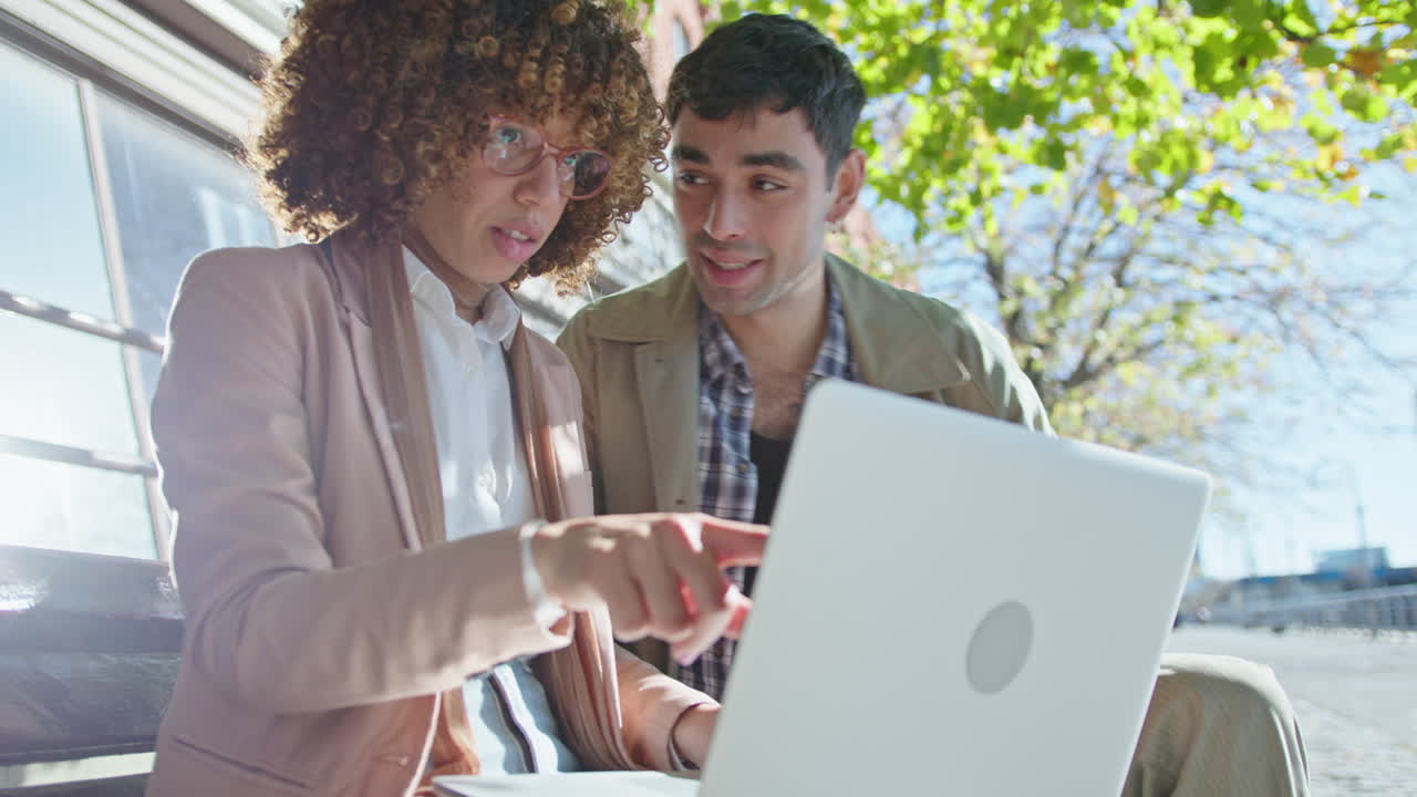Colleagues Working with Laptop and Speaking on the Street