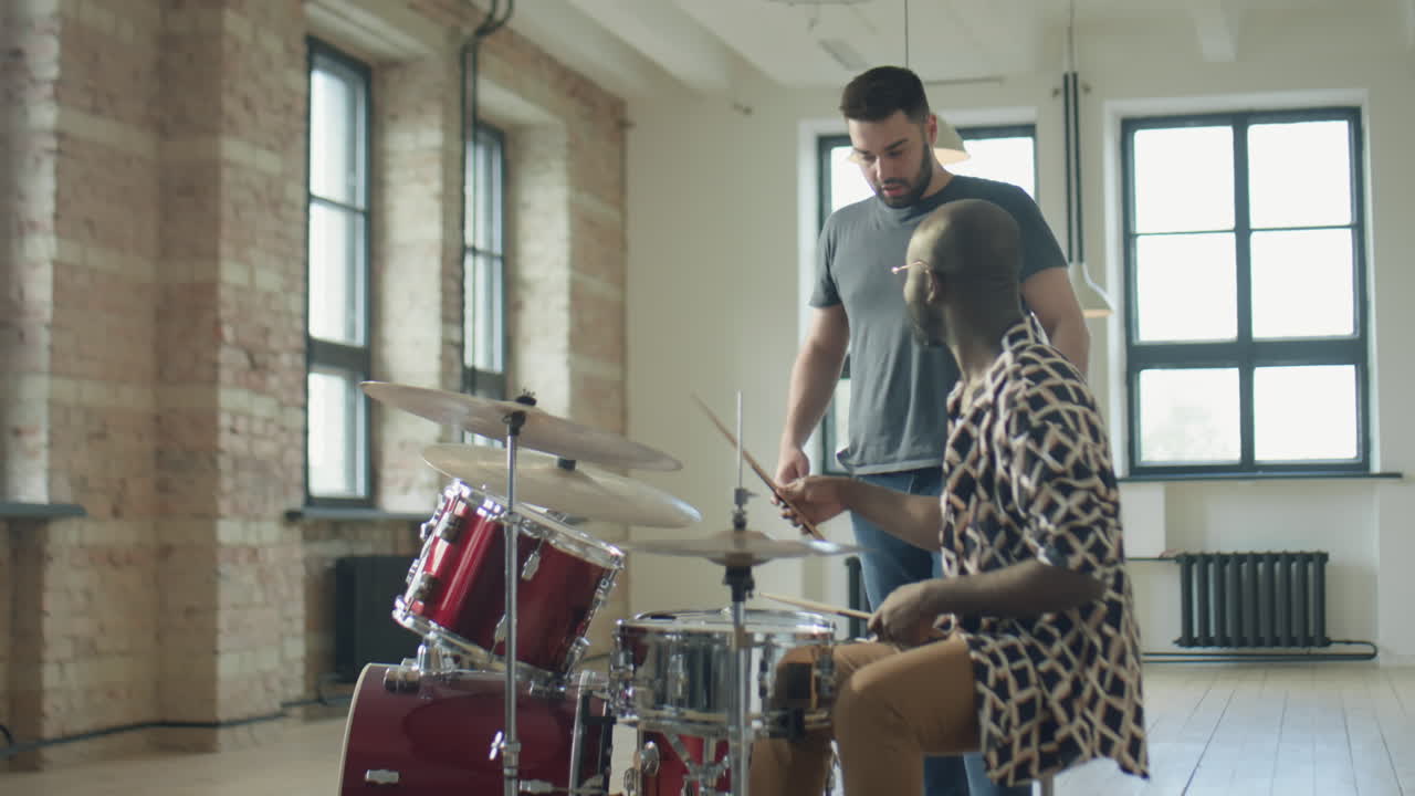 Insegnante di musica che spiega a un uomo afroamericano come tenere le bacchette
