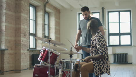 music teacher telling black man how to hold drumsticks