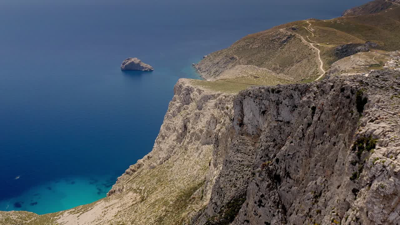 hermoso paisaje drone video de un pico rocoso, amorgos, mar azul, grecia aérea