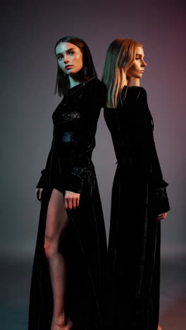 elegant models in black velvet gowns in a studio