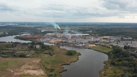 Drohnen-Panoramavideo-Aus-Der-Luft-Einer-Fabrik-Am-Flussufer-An-Einem-Bewölkten-Tag