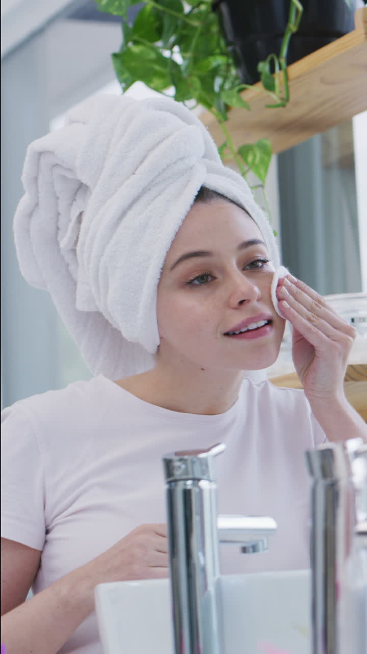 Young Woman Cleansing Her Face and Neck with Cotton Pad