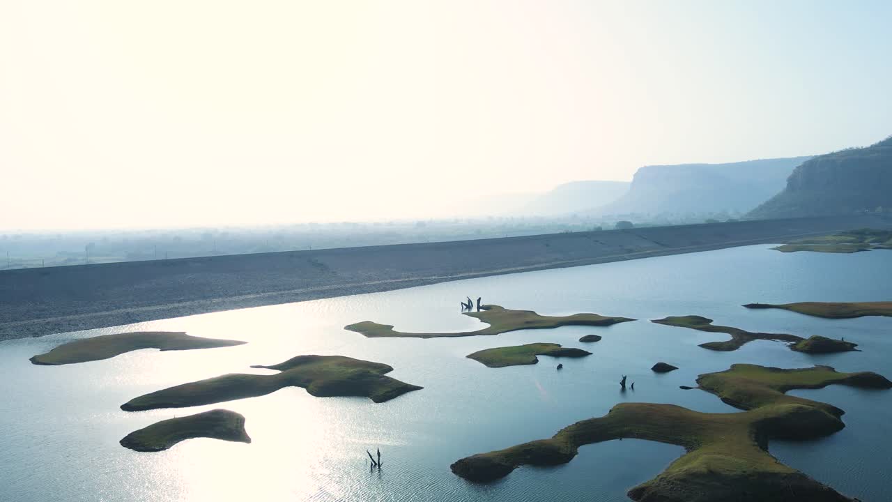 High-altitude drone shot of Karamchat Dam, offering a panoramic perspective of the water body and the surrounding terrain.