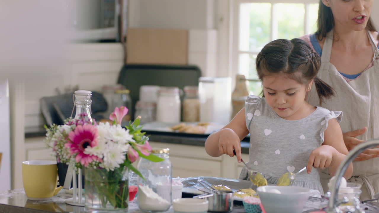 niña pequeña ayudando a su madre a hornear en la cocina poniendo masa de galletas en la bandeja preparando receta casera en casa con su madre enseñando a su hija el fin de semana