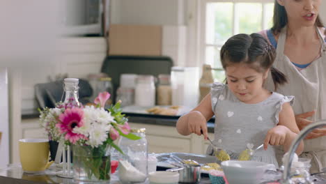 little girl helping mother bake in kitchen putting cookie dough onto tray preparing homemade recipe at home with mom teaching her daughter on weekend