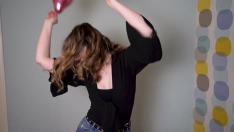 Mujer-Joven-Bailando-Y-Pasando-Un-Buen-Rato-Con-Globos-Flotantes-En-El-Aire