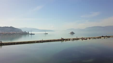 Toma-De-Camión-Del-Muelle-De-Nafplion-Con-El-Castillo-De-Boutzi-En-El-Fondo,-Grecia