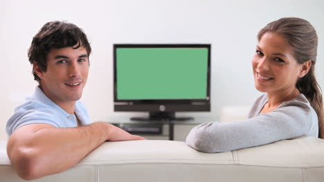 couple sitting together in front of the television