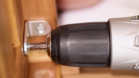a power drill secures screws into wooden furniture, showcasing efficient assembly in a well-lit environment