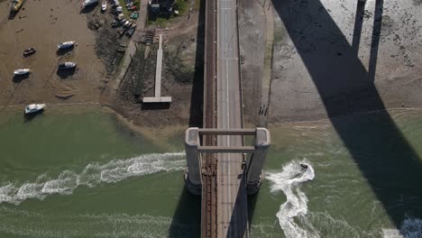 Jet-Ski-Pasando-Por-Debajo-Del-Puente-Kingsferry-En-El-Cruce-De-Sheppey-En-Inglaterra---Toma-Aérea