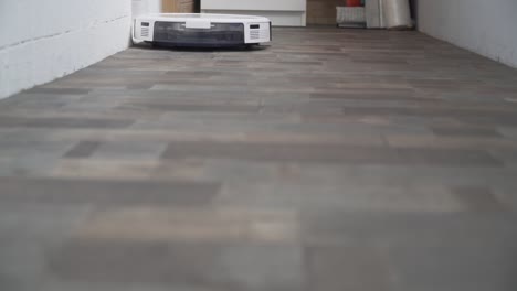 hogar inteligente. la aspiradora robot realiza la limpieza automática del apartamento en un determinado momento. ayudante inteligente en el hogar. un moderno limpiador robótico limpia el polvo en el suelo. tecnología de limpieza