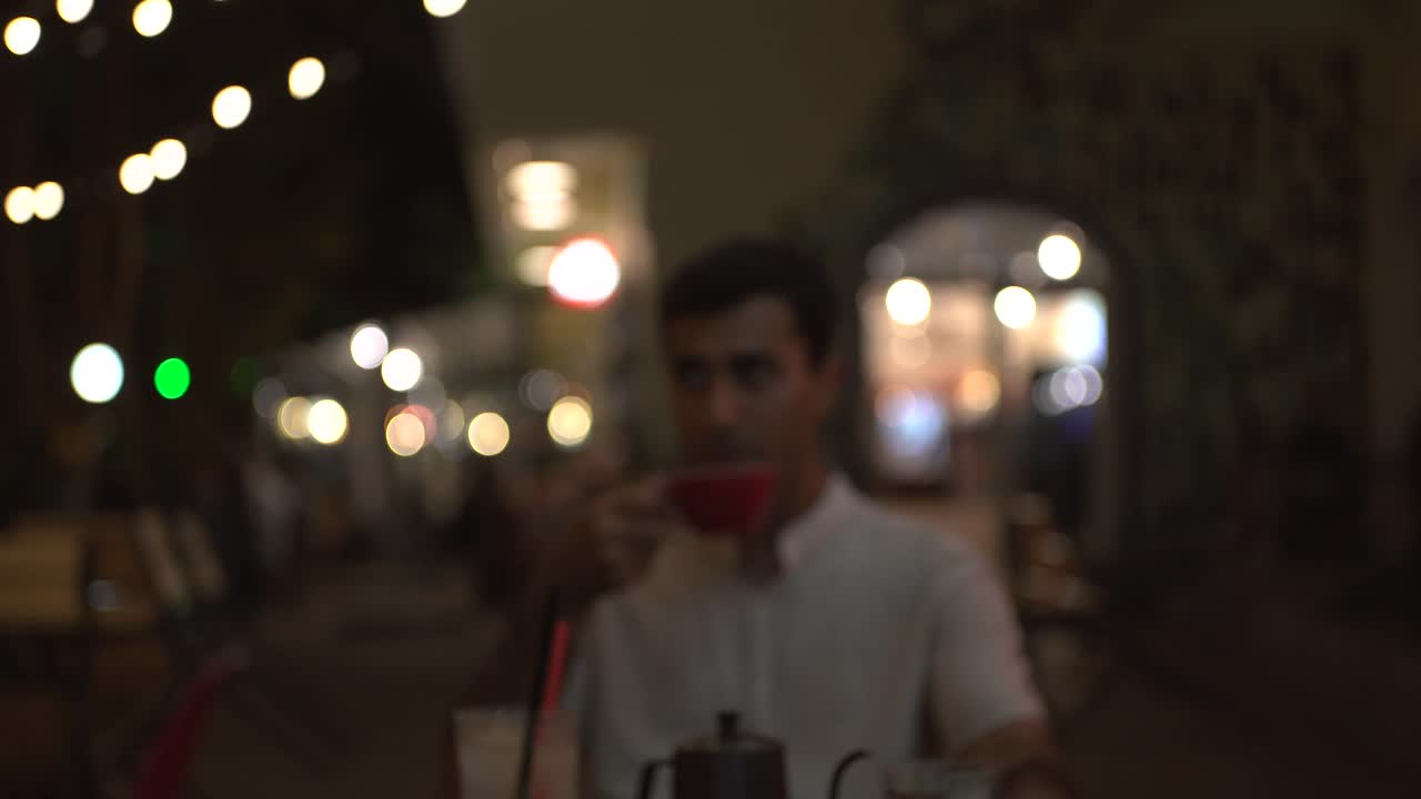 hombre bebiendo café al aire libre por la noche
