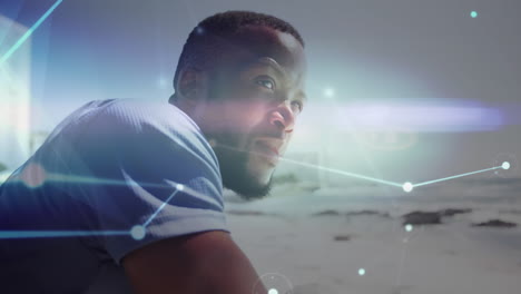 red brillante de conexiones contra el hombre afroamericano disfrutando de la vista en la playa