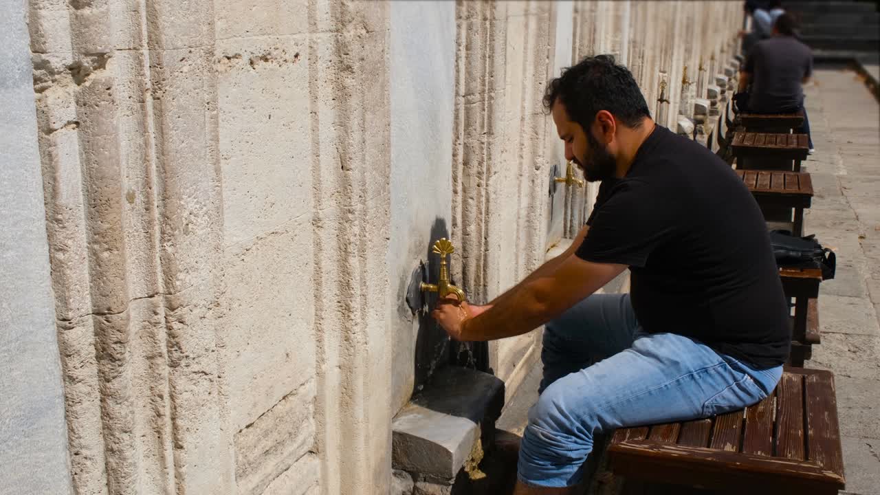 ablución, el hombre realiza la ablución en una mezquita histórica, el hombre wudu
