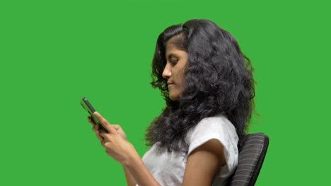 girl-using-mobile-and-smiles-on-croma-from-side-view