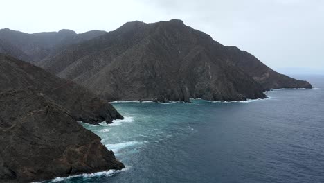 Aerial-view-of-rocky-cliffs-in-the-coastline-of-the-volcanic-island-of-La-Gomera,-Spain