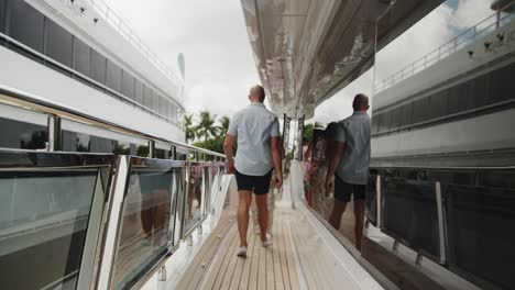 man walking on a yacht during a boat show, handheld camera following the man