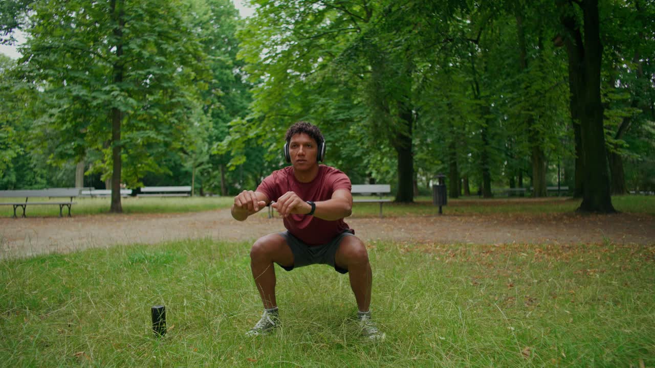 Uomo che si allena con le cuffie al parco