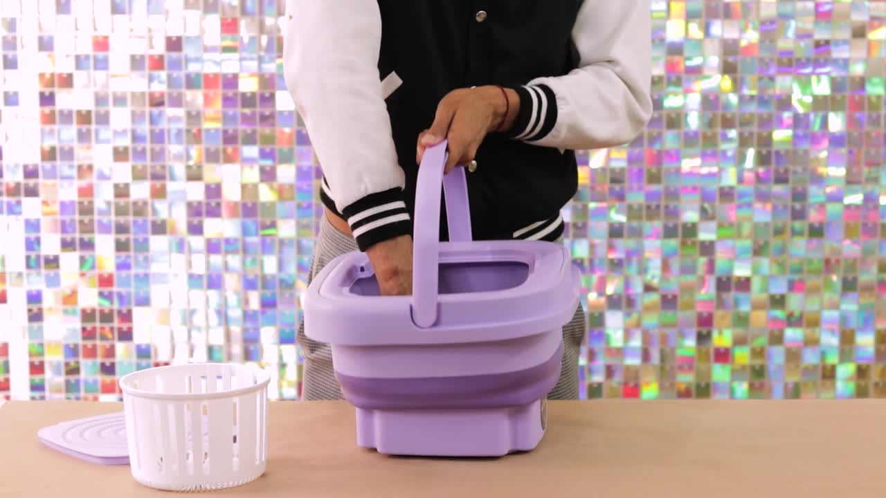 Setting up small washing machine on the table, portable home appliance