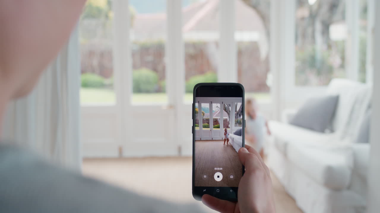 madre tomando video del bebé usando un teléfono inteligente disfrutando de fotografiar a un bebé feliz con una cámara de teléfono móvil compartiendo el estilo de vida de la maternidad en las redes sociales imágenes de 4k