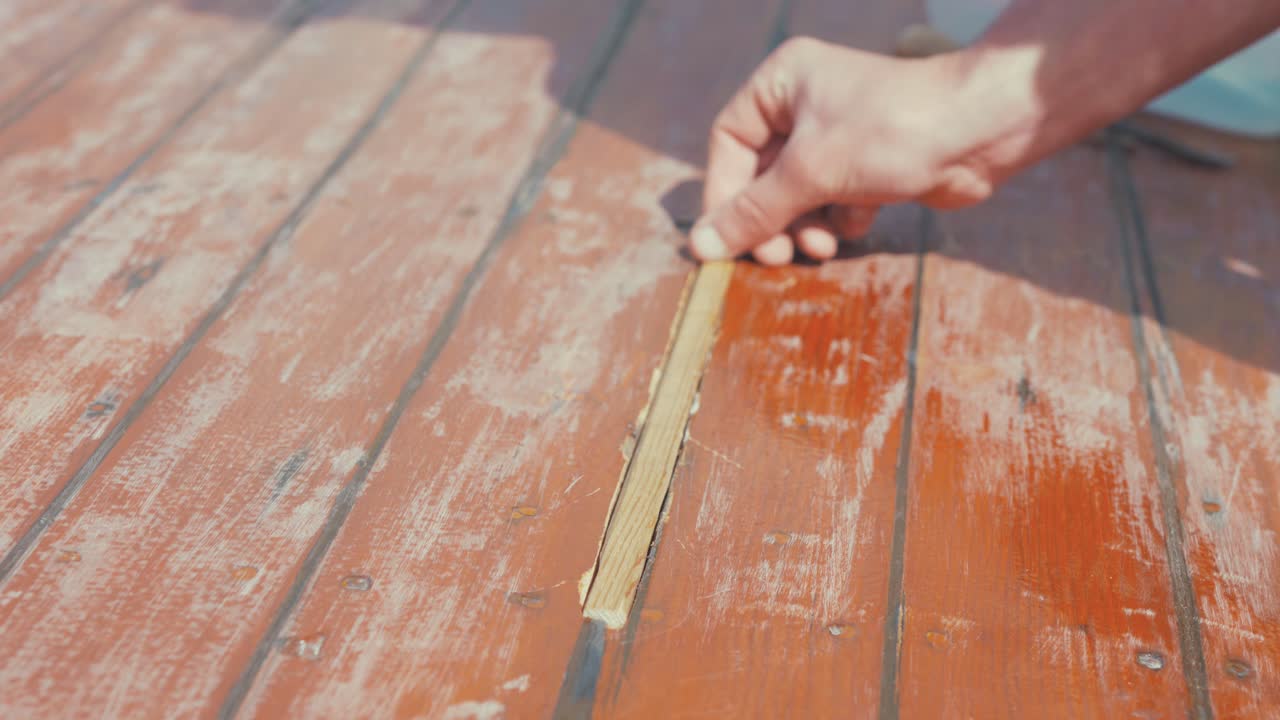Fitting wooden spline insert into wooden boat roof planking rubbing hand across, SLOW MOTION