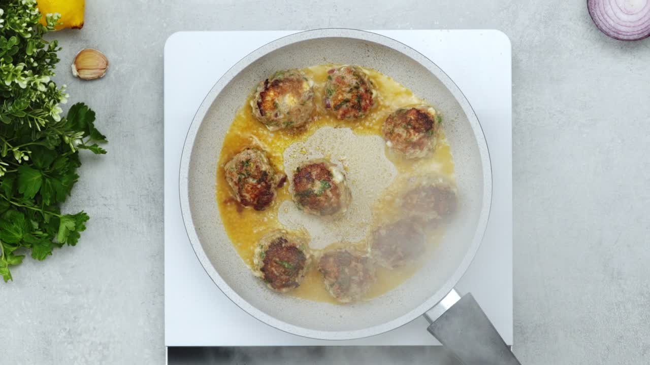 Unrecognizable person cooking meatballs on frying pan with oil