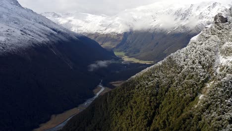 Increíble-Valle-Con-Montañas-Nevadas-Arriba-Con-Un-Río-Corriendo-En-Un-Día-Nublado-En-Nueva-Zelanda