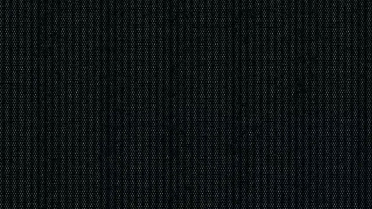 Detailní textura tmavé černé látky.